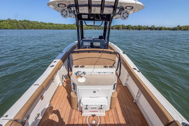 Slide: The Image of 2021 Sea Hunt Ultra 255 SE boat interior with console and seating on calm water. - 10