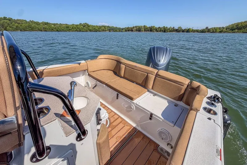 Slide: The Image of 2021 Sea Hunt Ultra 255 SE boat interior with seating, on a calm lake. - 12