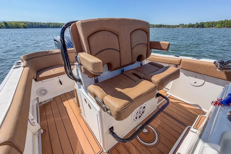 Slide: The Image of 2021 Sea Hunt Ultra 255 SE boat interior with brown seating on a sunny day. - 13