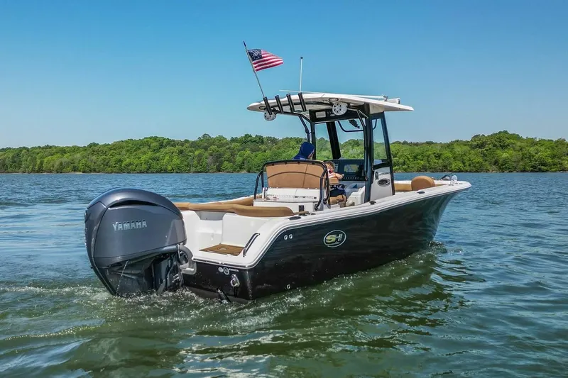 Slide: The Image of 2021 Sea Hunt Ultra 255 SE boat cruising on a lake with American flag. - 5