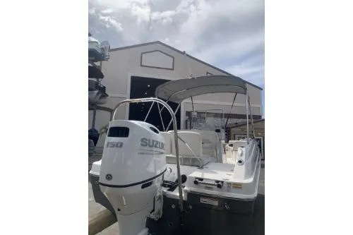 Slide: The Image of 2021 Hurricane Center Console 19 OB boat with Suzuki engine, parked near a warehouse. - 4