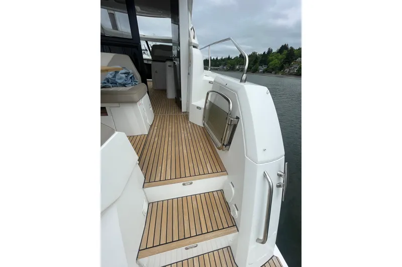 Slide: The Image of 2017 Jeanneau Leader 46 yacht with teak deck, docked by a scenic shoreline. - 54