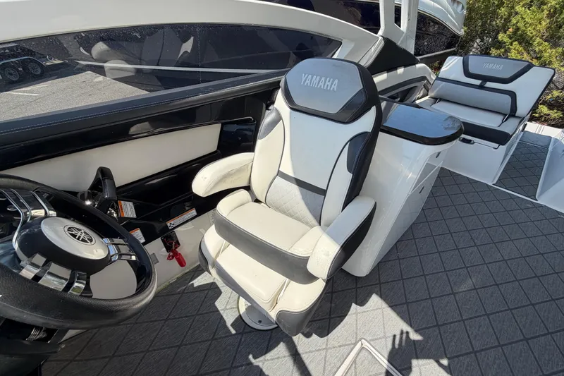 Slide: The Image of 2020 Yamaha Boats 275SD cockpit with steering wheel and cushioned seating. - 12