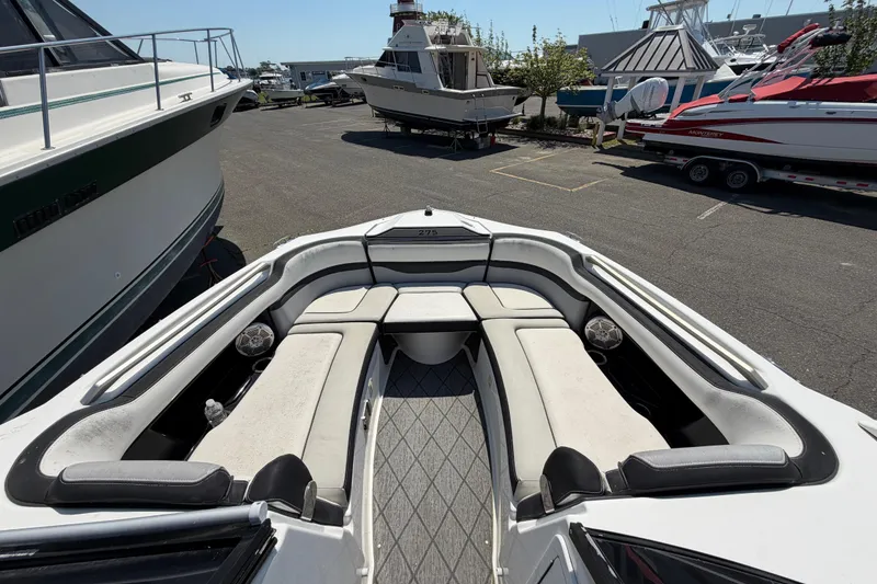 Slide: The Image of 2020 Yamaha Boats 275SD with spacious seating, docked among other boats. - 17