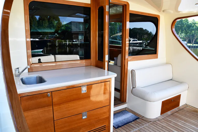 Slide: The Image of 2020 Palm Beach Motor Yachts PB52 interior with wooden cabinetry and seating area. - 2