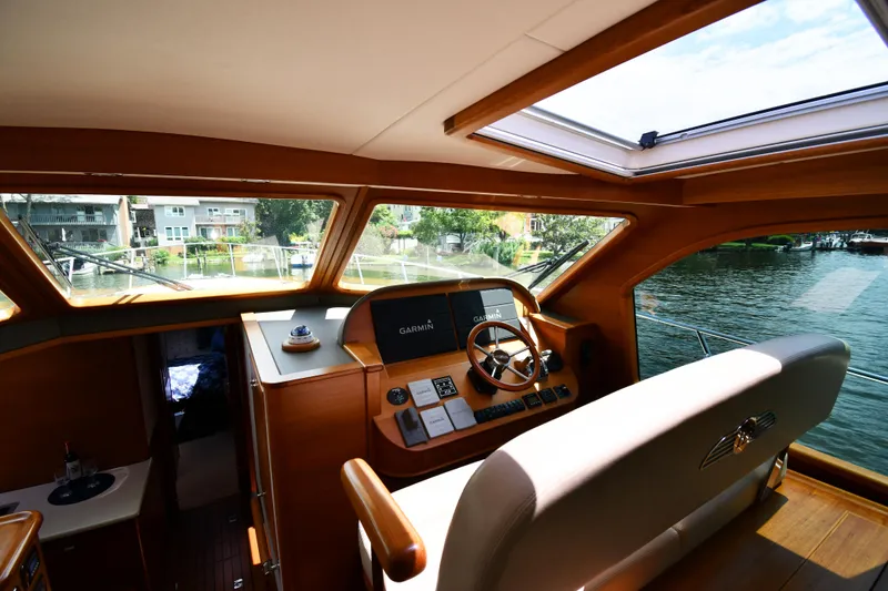 Slide: The Image of Interior view of 2020 Palm Beach Motor Yachts PB52 helm with wooden accents and water view. - 26