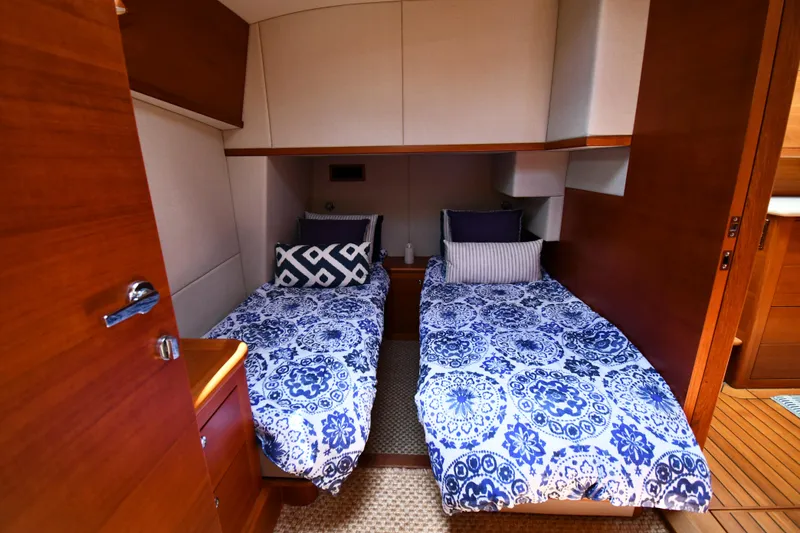 Slide: The Image of 2020 Palm Beach Motor Yachts PB52 cabin with twin beds and blue patterned bedding. - 45
