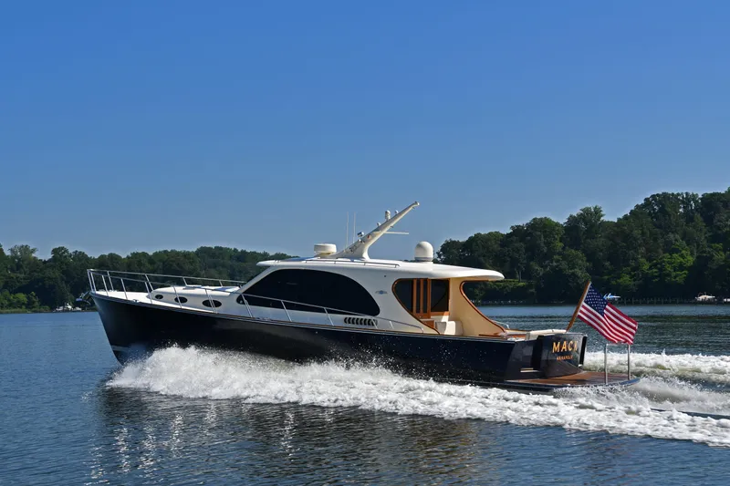 Slide: The Image of 2020 Palm Beach Motor Yachts PB52 cruising on a serene lake under a clear blue sky. - 6