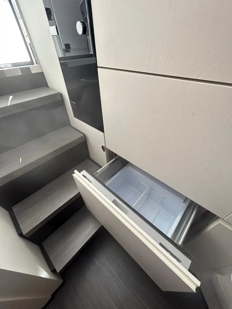 Slide: The Image of 2024 Azimut Verve 48 yacht interior with open drawer and modern staircase. - 19