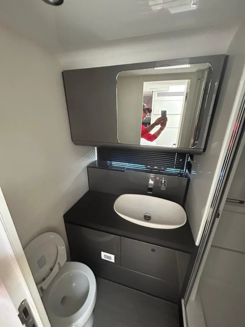 Slide: The Image of 2024 Azimut Verve 48 yacht bathroom with modern sink, mirror, and toilet. - 23