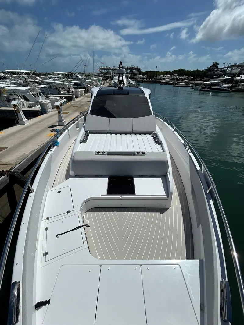 Slide: The Image of 2024 Azimut Verve 48 yacht docked in a marina under a partly cloudy sky. - 4