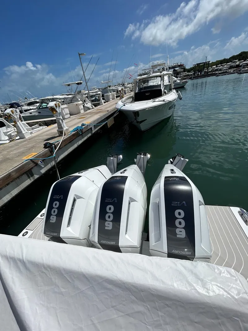 Slide: The Image of 2024 Azimut Verve 48 with triple outboard engines docked at a marina. - 5