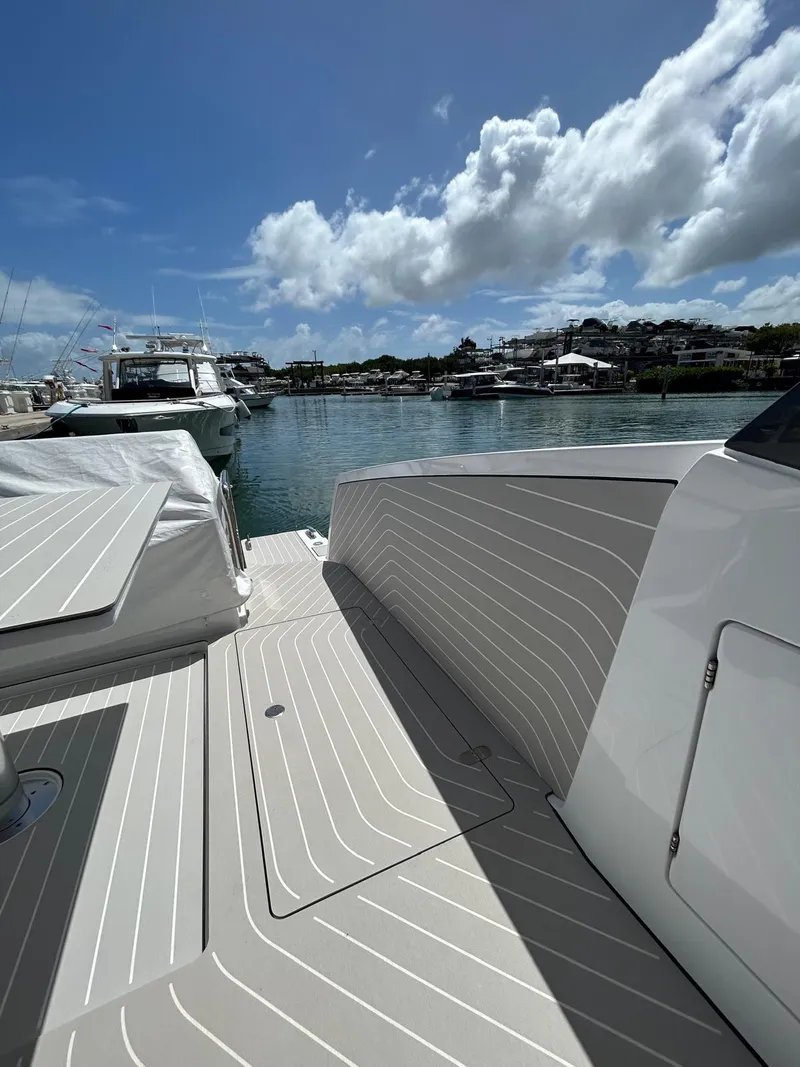 Slide: The Image of 2024 Azimut Verve 48 yacht docked, showcasing sleek deck design under a bright blue sky. - 7