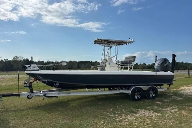 The Image of 2023 Skeeter SX240 boat on trailer, parked on grassy field under blue sky. - 1