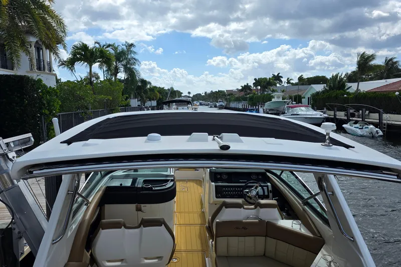 Slide: The Image of 2015 Sea Ray SLX 350 boat interior with canal view, featuring luxurious seating and helm. - 15