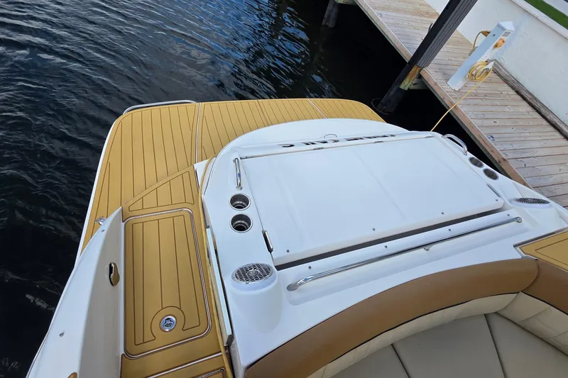 Slide: The Image of 2015 Sea Ray SLX 350 boat deck with tan and white seating, docked by wooden pier. - 17
