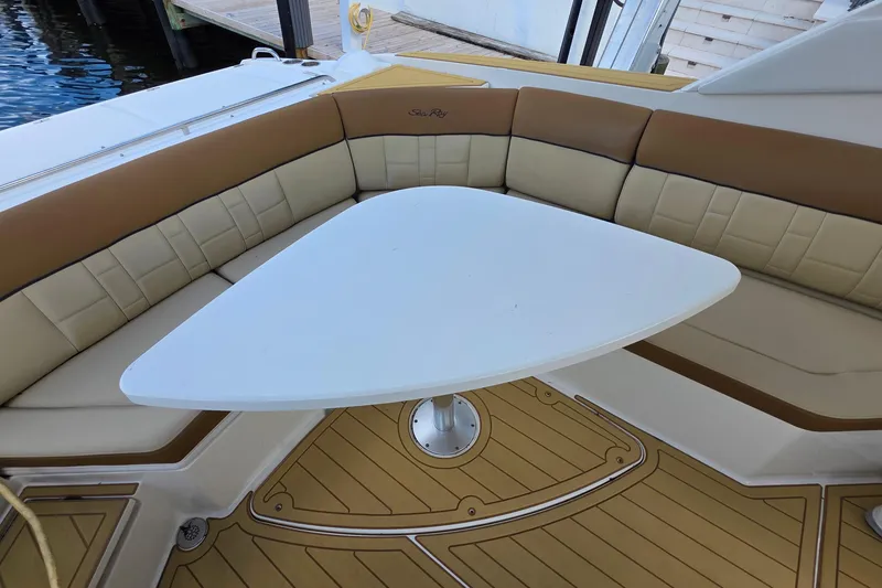 Slide: The Image of 2015 Sea Ray SLX 350 boat interior with cushioned seating and triangular table. - 20