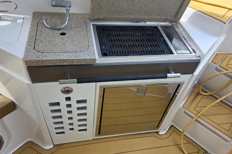 Slide: The Image of Outdoor kitchen on 2015 Sea Ray SLX 350 boat with grill and sink. - 21