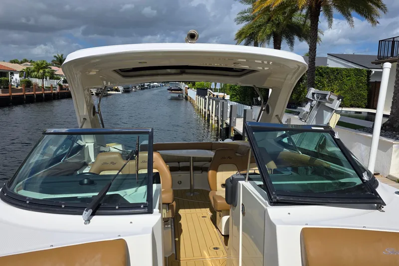 Slide: The Image of 2015 Sea Ray SLX 350 boat docked by a canal with palm trees. - 38