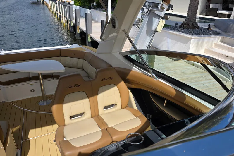 Slide: The Image of 2015 Sea Ray SLX 350 boat interior with tan seating and table by the water. - 40