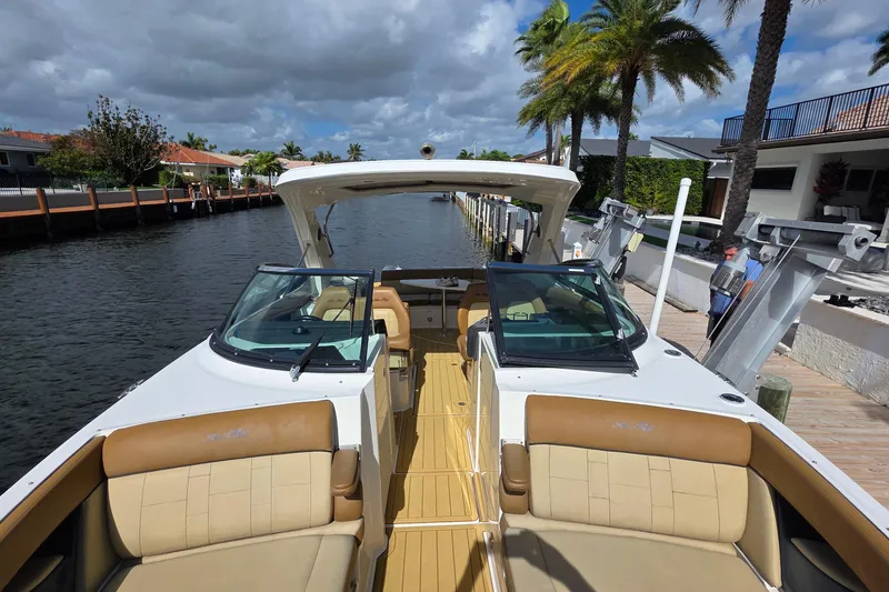 Slide: The Image of 2015 Sea Ray SLX 350 boat docked by a canal with palm trees. - 46