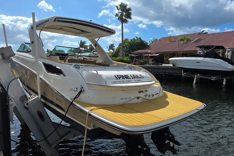 Slide: The Image of 2015 Sea Ray SLX 350 boat docked near waterfront property under a sunny sky. - 6