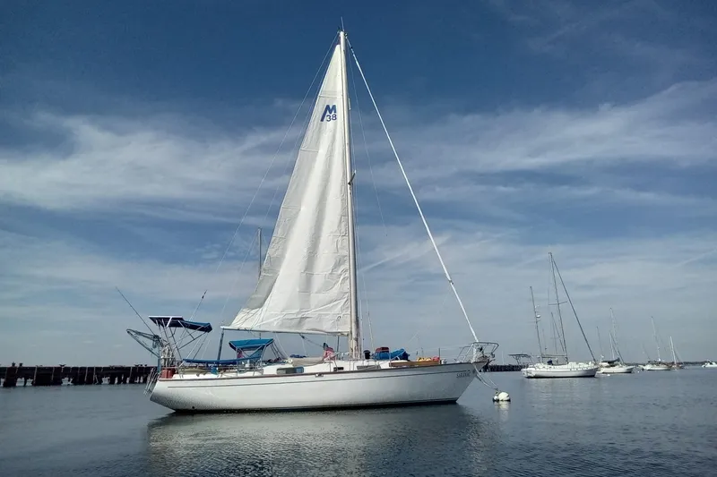 The Image of 1979 Morgan 382 sailboat anchored on calm water under a clear blue sky. - 0