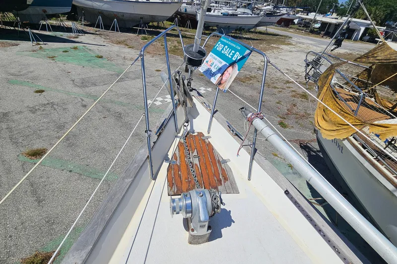 Slide: The Image of 1979 Morgan 382 sailboat for sale, docked in a boatyard with other vessels. - 10