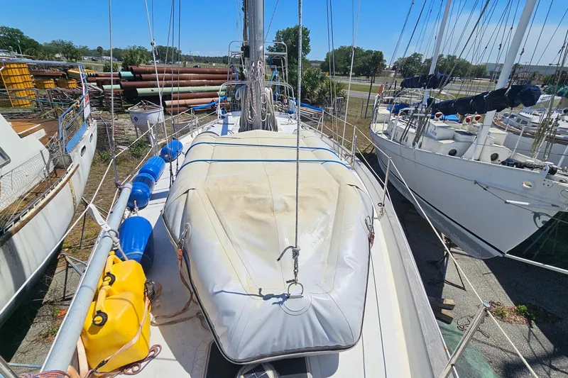 Slide: The Image of 1979 Morgan 382 sailboat on deck, surrounded by other boats in a marina. - 11