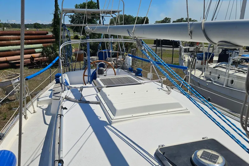 Slide: The Image of 1979 Morgan 382 sailboat deck with rigging and steering wheel in a marina. - 14