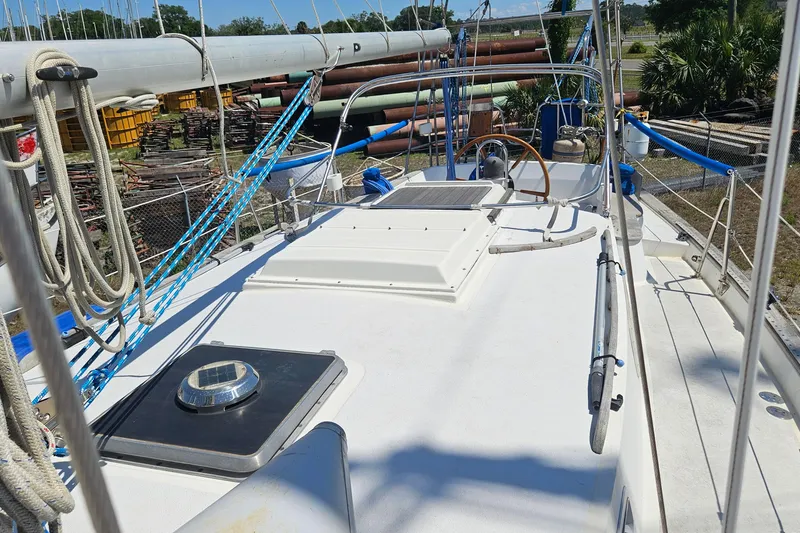 Slide: The Image of 1979 Morgan 382 sailboat deck with ropes and steering wheel in a marina setting. - 15