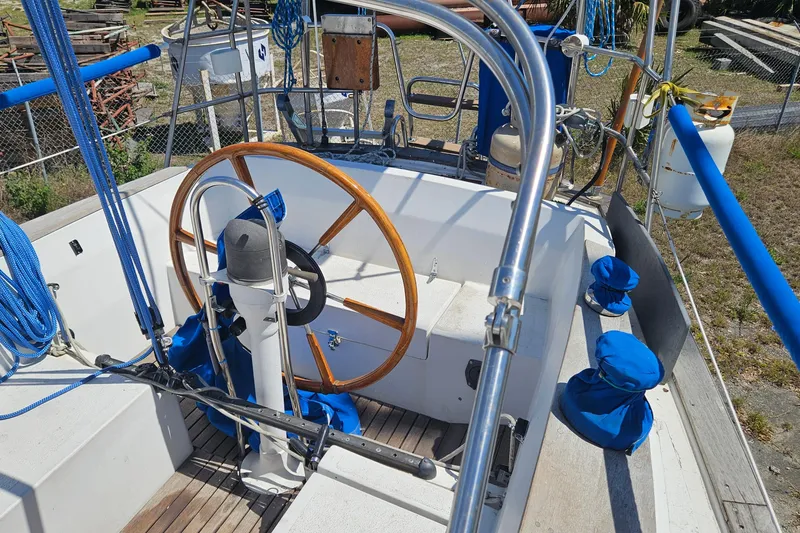 Slide: The Image of Cockpit of a 1979 Morgan 382 sailboat with wooden steering wheel and blue accents. - 17