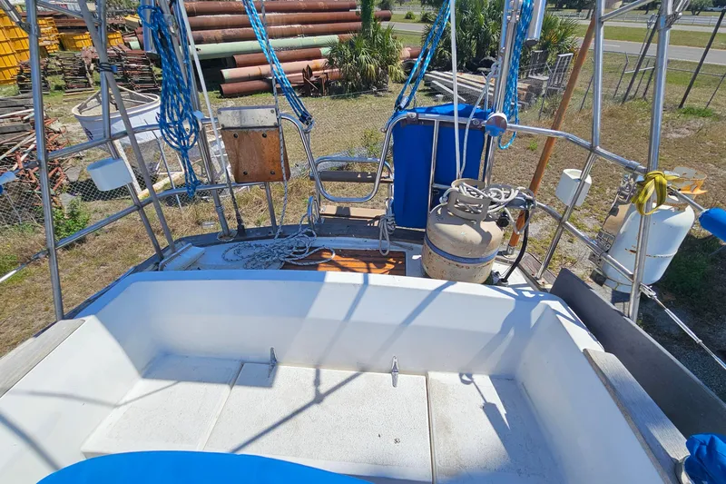 Slide: The Image of 1979 Morgan 382 sailboat deck with ropes and equipment, docked in a yard. - 21