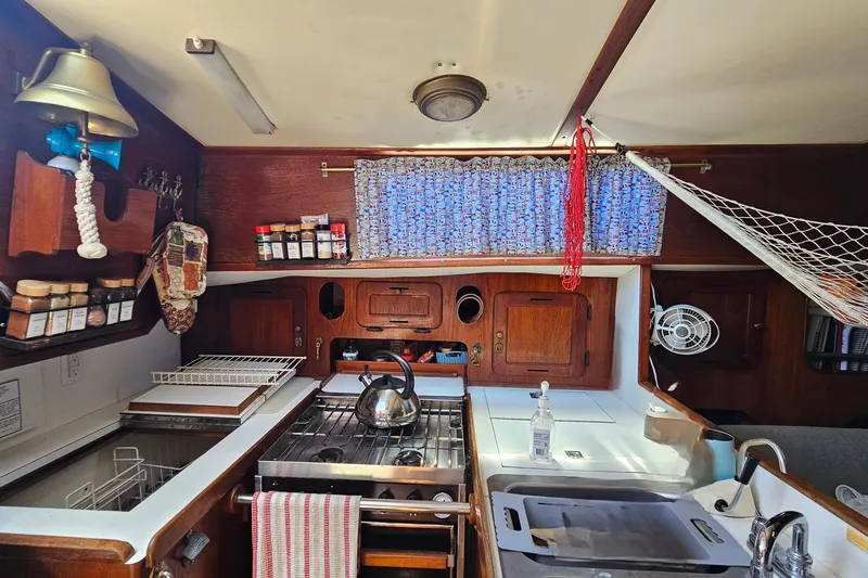 Slide: The Image of 1979 Morgan 382 yacht kitchen interior with stove, spices, and nautical decor. - 27