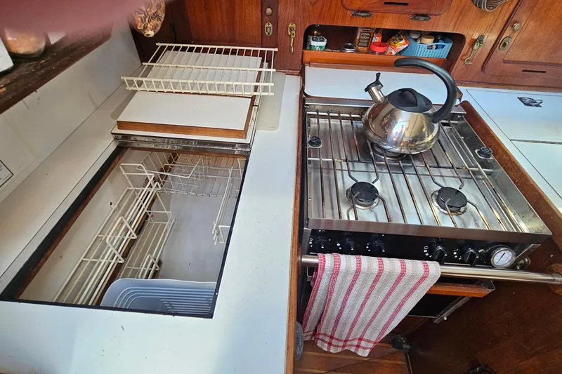 Slide: The Image of 1979 Morgan 382 yacht kitchen with stove, kettle, and storage compartments. - 29