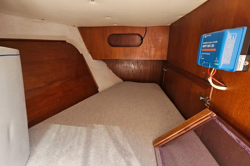Slide: The Image of Interior cabin of a 1979 Morgan 382 sailboat with wooden paneling and a charge controller. - 30