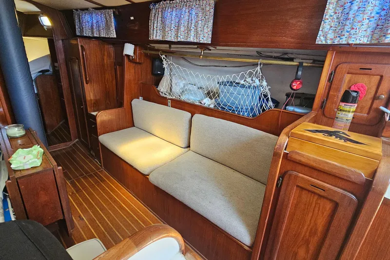 Slide: The Image of Interior of a 1979 Morgan 382 sailboat with wooden furnishings and cozy seating. - 35