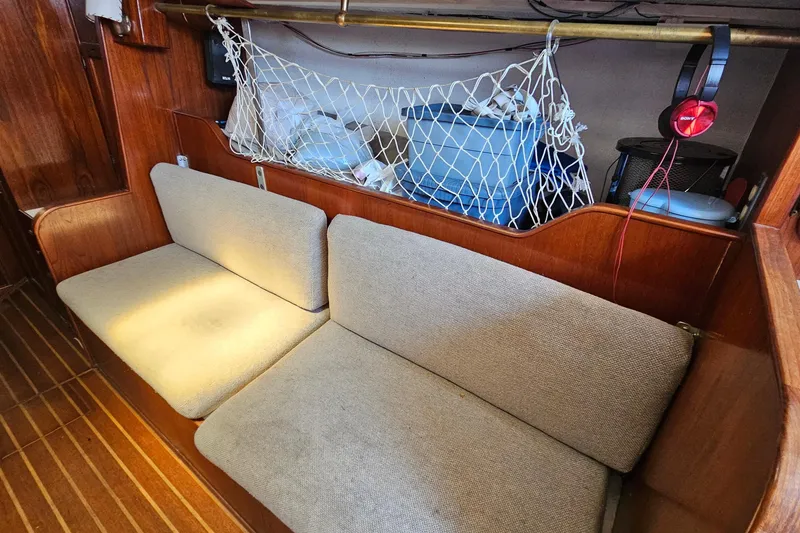 Slide: The Image of Interior of a 1979 Morgan 382 sailboat with cushioned seating and storage net. - 36