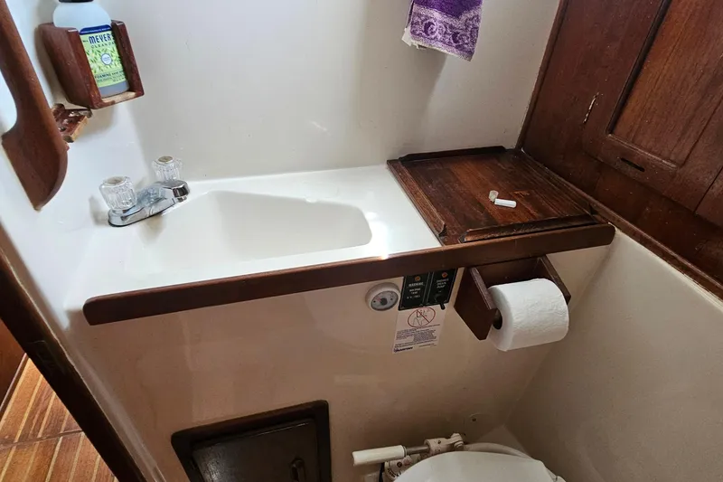 Slide: The Image of 1979 Morgan 382 yacht bathroom with sink, wooden accents, and toilet paper holder. - 43