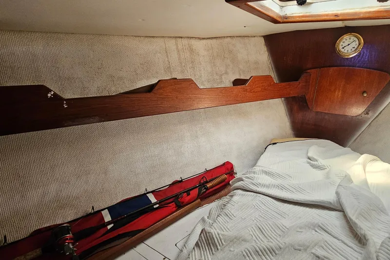 Slide: The Image of Interior cabin of a 1979 Morgan 382 sailboat with wooden accents and a cozy sleeping area. - 44