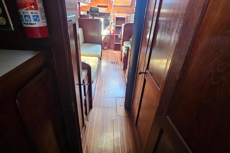 Slide: The Image of Interior view of a 1979 Morgan 382 sailboat with wooden paneling and seating area. - 45