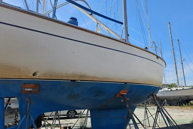 Slide: The Image of 1979 Morgan 382 sailboat on stands, hull view, clear sky background. - 49