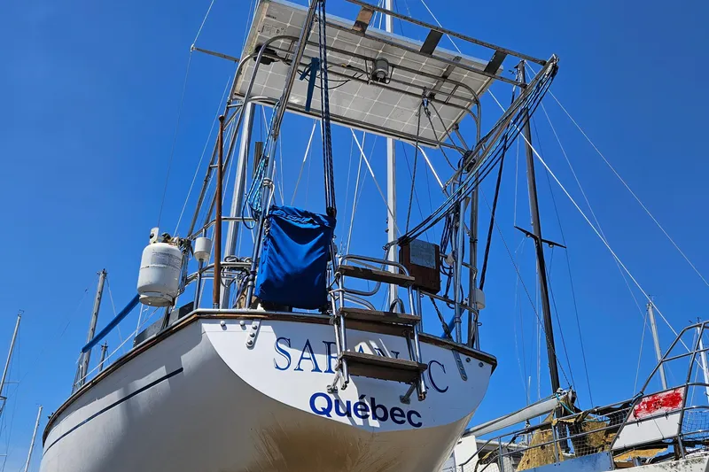 Slide: The Image of 1979 Morgan 382 sailboat docked, Quebec registration, clear blue sky background. - 8