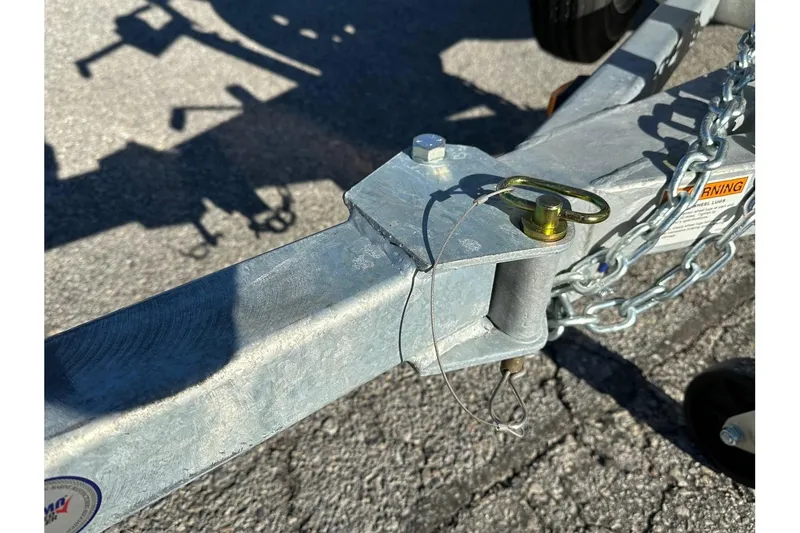 Slide: The Image of Trailer hitch of 2026 Smoker Craft Angler 16 SC boat, featuring safety chains and pin. - 18