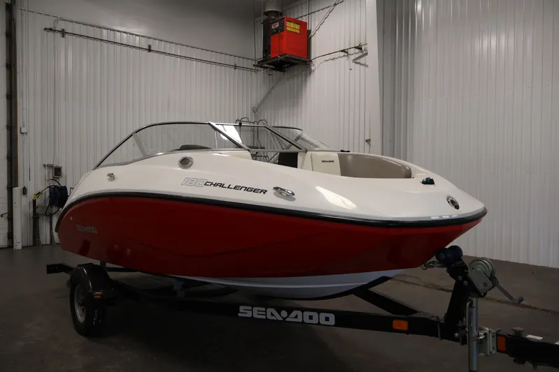 Slide: The Image of 2011 Sea-Doo Challenger 180 boat in a garage, red and white design. - 3