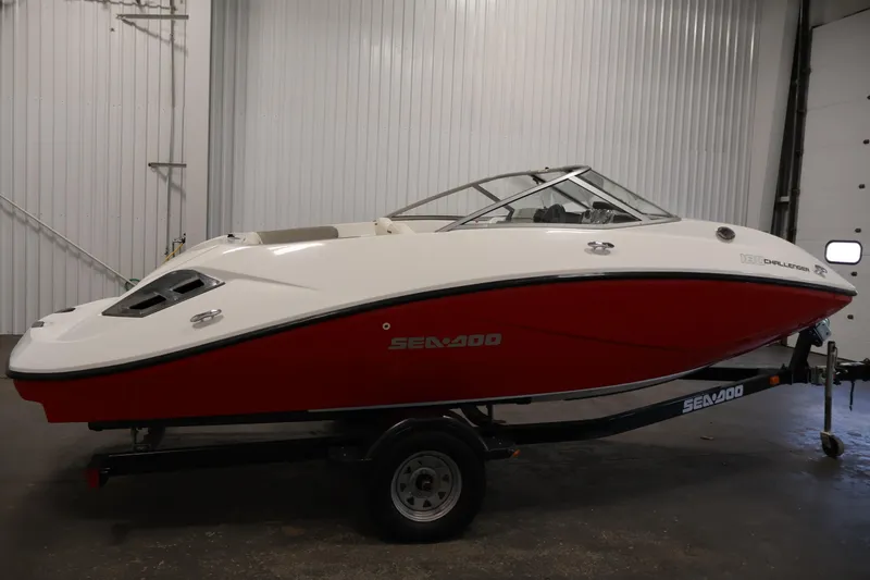 Slide: The Image of 2011 Sea-Doo Challenger 180 boat with red and white design in a garage setting. - 4
