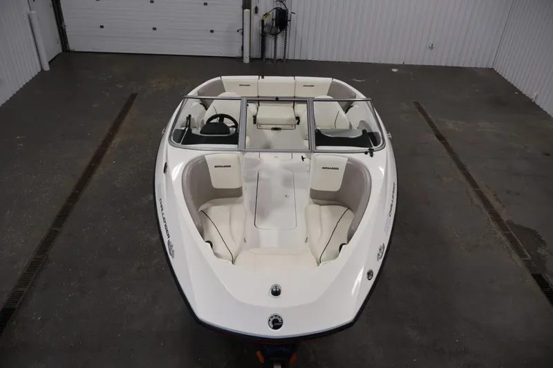 Slide: The Image of 2011 Sea-Doo Challenger 180 boat in a garage, showcasing sleek design and seating layout. - 9