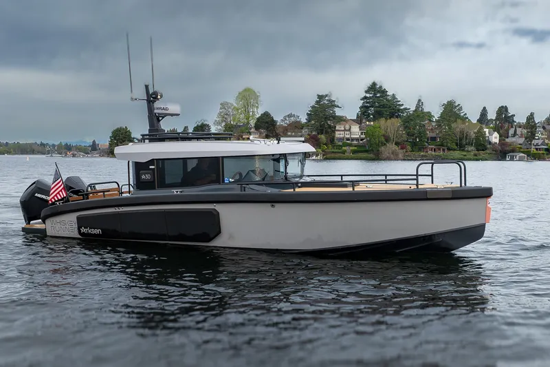 Slide: The Image of 2023 Arksen 30 Adventure boat on a lake with scenic shoreline background. - 1