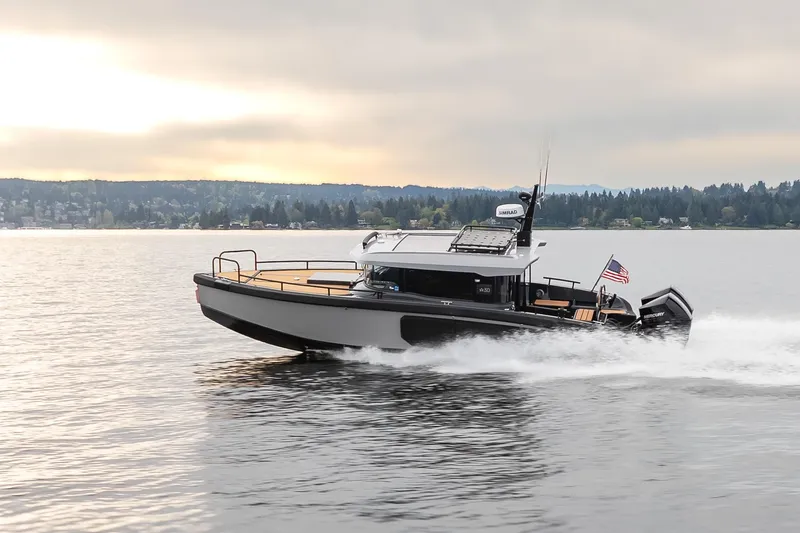 Slide: The Image of 2023 Arksen 30 Adventure boat cruising on a serene lake at sunset. - 2