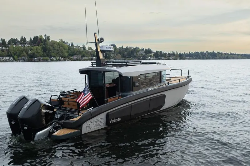 Slide: The Image of 2023 Arksen 30 Adventure boat on a serene lake with lush shoreline. - 22